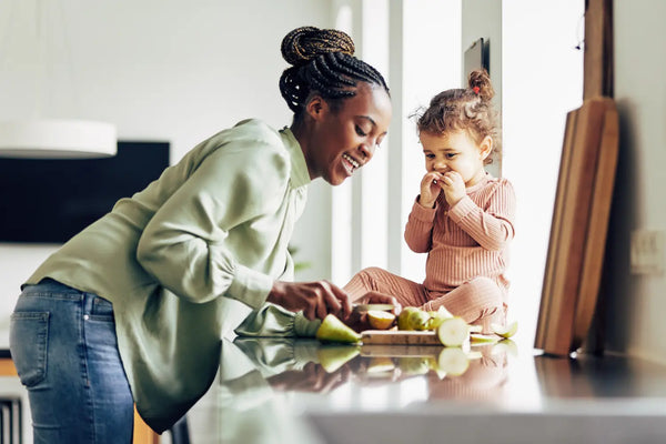 Mother and child enjoying healthy snacks in the kitchen.