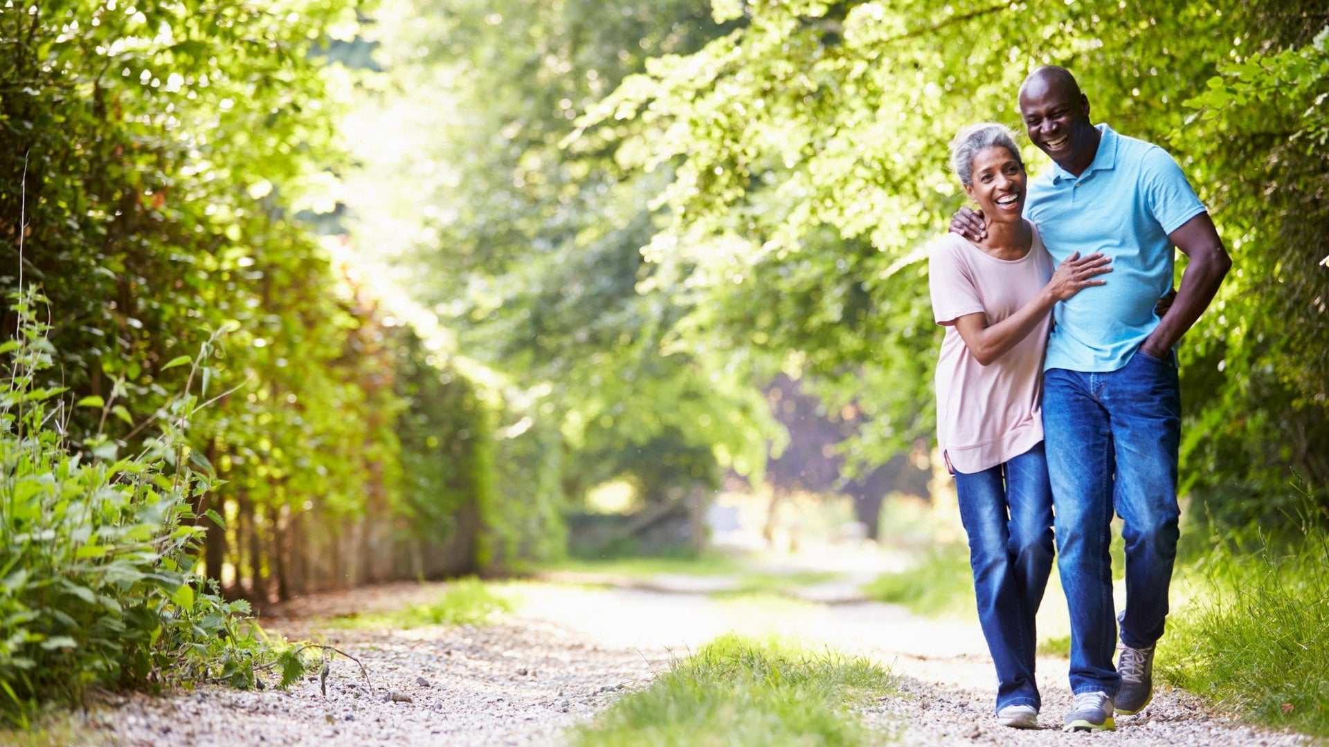 Happy couple walking on a sunny nature trail.