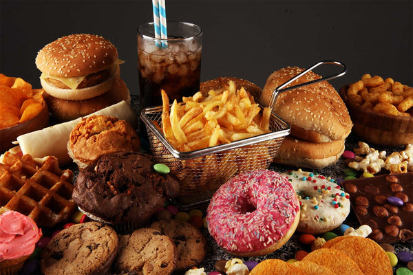 Assortment of fast food and snacks including burgers, fries, donuts, and soda.
