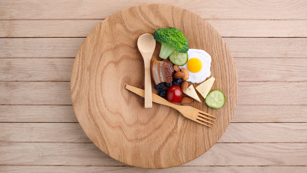 Diet-friendly small portion of diverse healthy foods on a wooden plate.