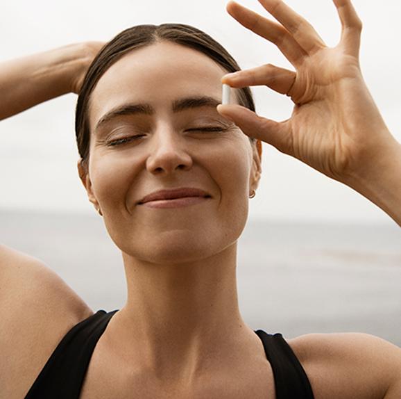
                Woman smiling serenely by the ocean.