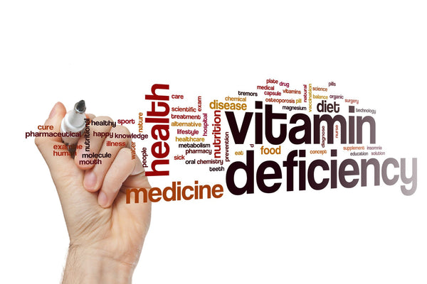 Hand writing vitamin deficiency word cloud on white background.