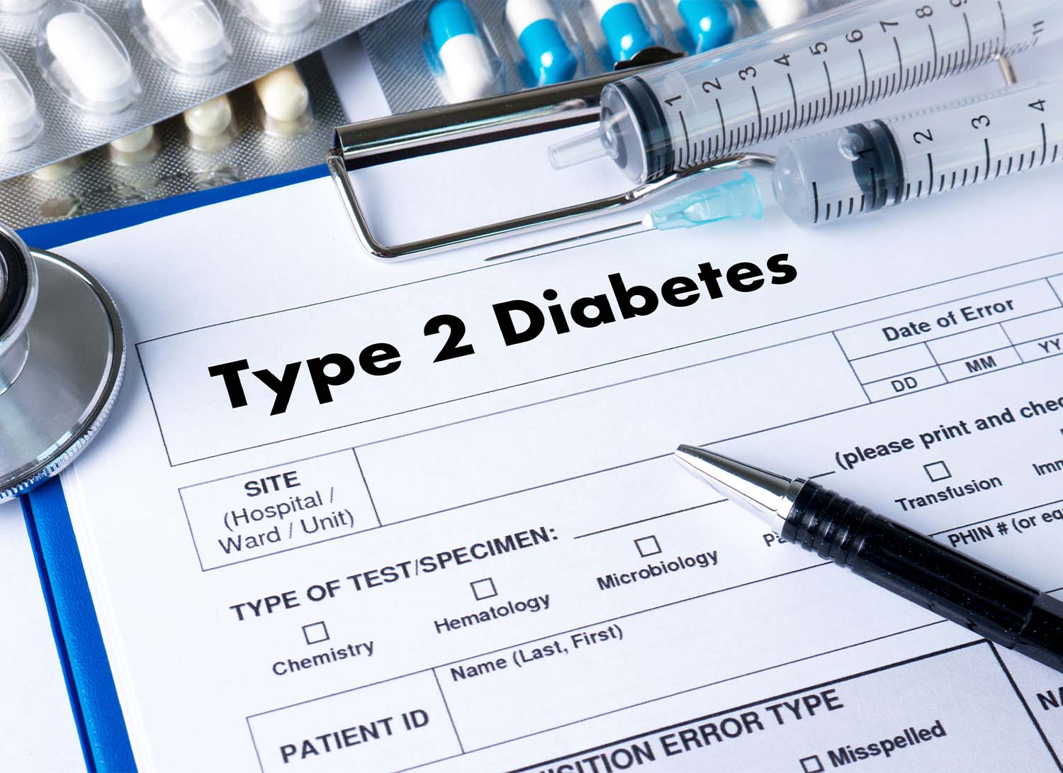 Medical form labeled Type 2 Diabetes with a pen and syringe nearby.