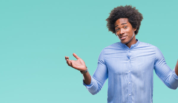 Man shrugging in striped shirt against turquoise background.
