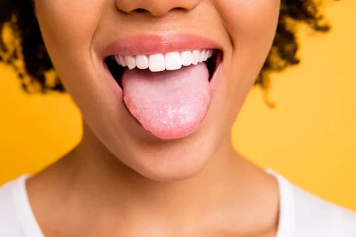 Smiling person showing tongue on yellow background.