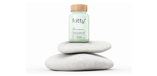 Fatty15's C15 supplement on stacked stones, natural background.